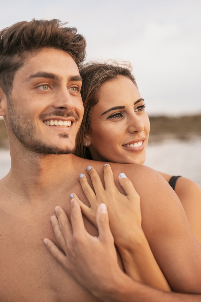 Una pareja abrazada junto al mar